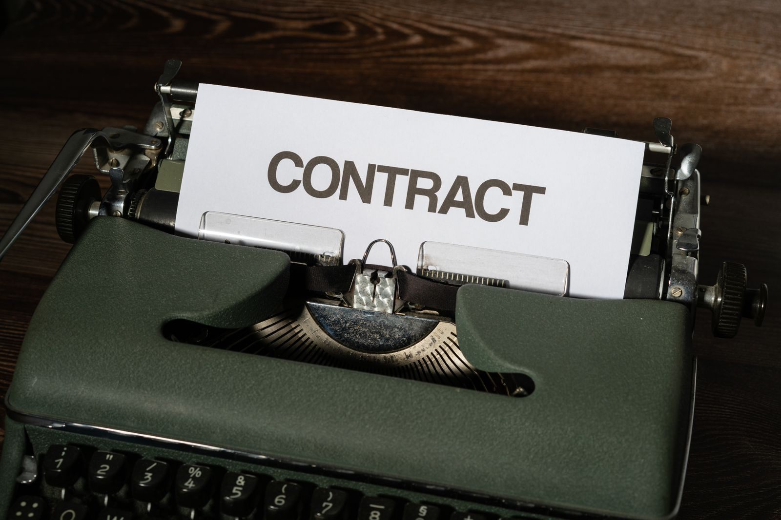 Vintage typewriter with a page titled Contract, a reminder to read any we beat any cruise price promise