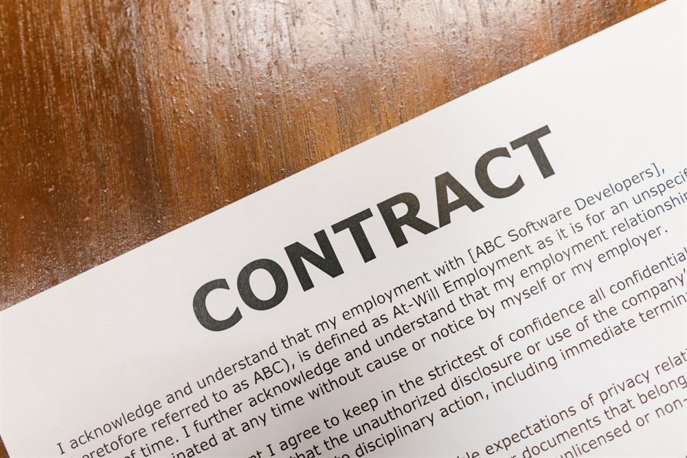 Close-up of a printed contract lying on a wooden table