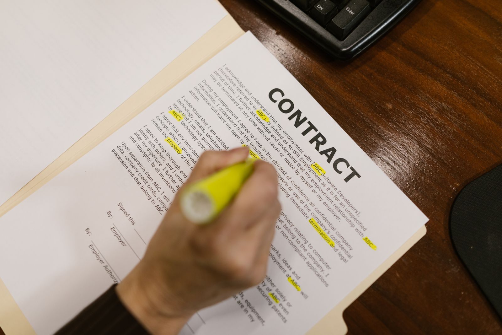 Hand highlighting the terms of a printed contract, the way to read a cruise best price guarantee