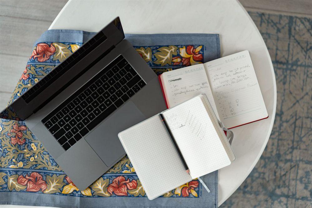 Laptop and open notebooks on a table, ready for comparing two cruise quotes